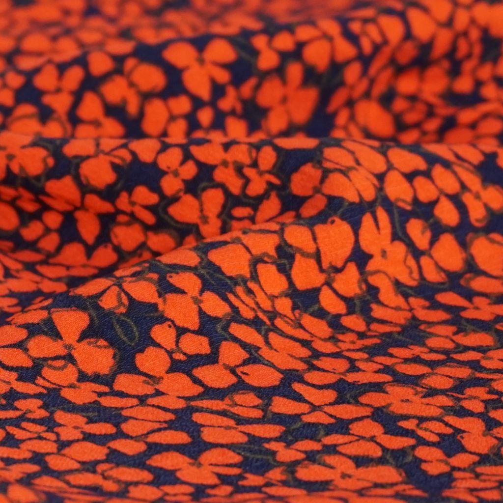 Viskose Crepe mit Nylon rotorange Blüten auf dunkelblau