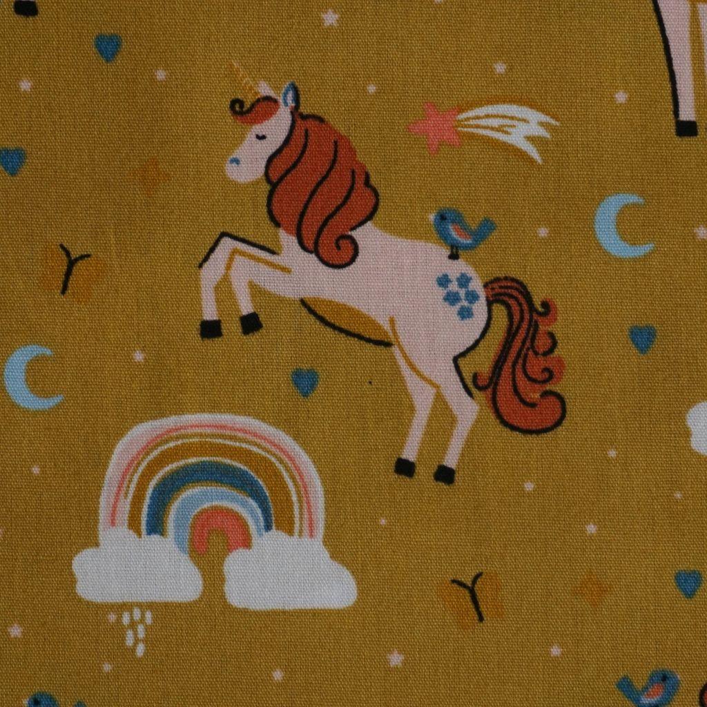 Baumwollstoff Motivdruck Einhorn und Regenbogen senfgelb